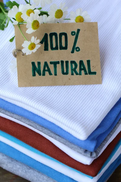 Pilha de roupas coloridas com etiqueta orgânica — Fotografia de Stock