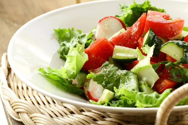 Salad with tomato cucumbers and radishes dressed with olive oil — Stock Photo, Image