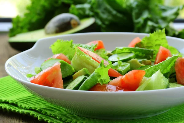 Taze salata avokado ve ahşap bir masa üzerinde domates — Stok fotoğraf