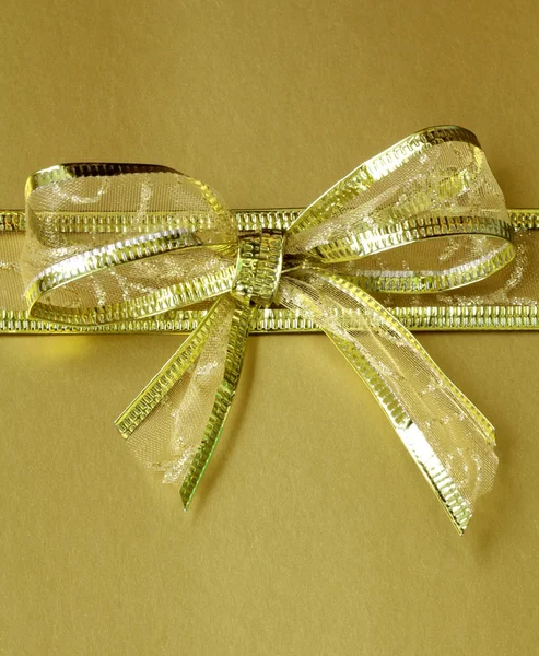 Golden ribbon tied bow for holiday background — Stock Photo, Image