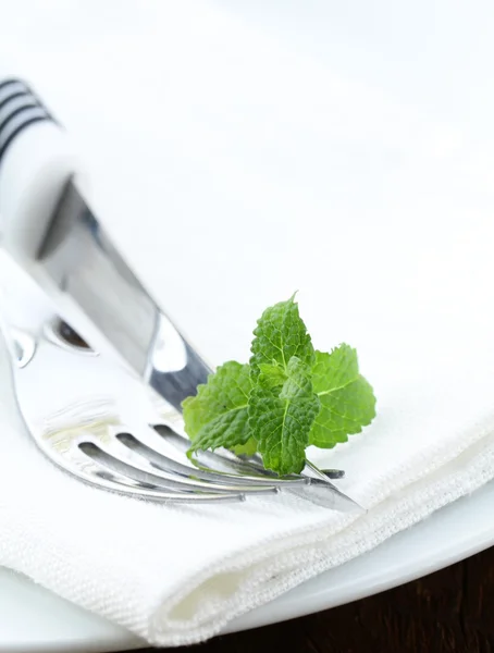 Cubertería, tenedor y cuchillo en un plato blanco —  Fotos de Stock
