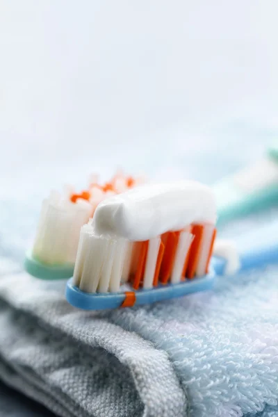 Couple toothbrushes with toothpaste on a towel — Stock Photo, Image