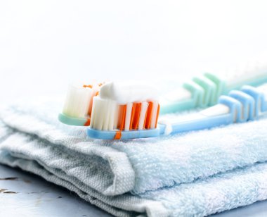 Couple toothbrushes with toothpaste on a towel clipart