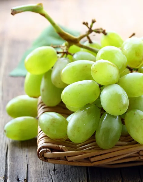 Green ripe sweet grapes on a wooden table — Stock Photo, Image