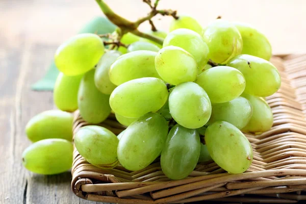Zielony dojrzałe słodkie winogrona na drewnianym stołem — Zdjęcie stockowe