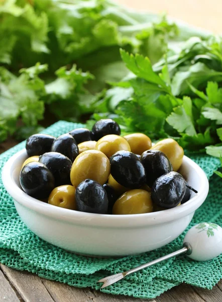 Закуска черно-зеленые оливки на деревянном столе — стоковое фото