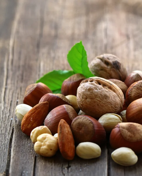 Blanda nötter - valnötter, hasselnötter, mandel på ett träbord — Stockfoto