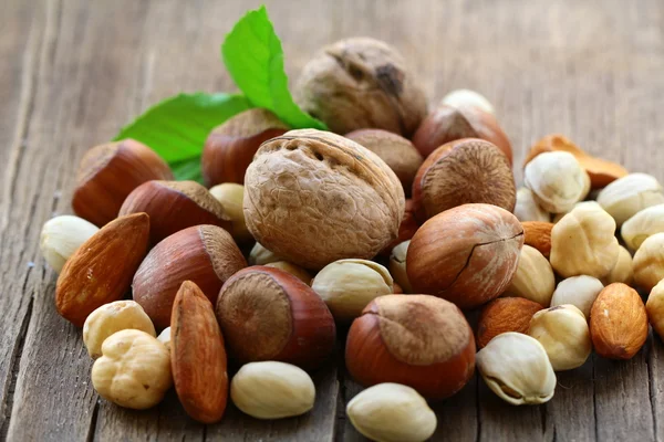 Blanda nötter - valnötter, hasselnötter, mandel på ett träbord — Stockfoto