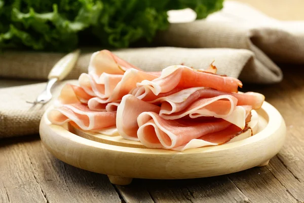 Delicious sliced ham on wooden plate — Stock Photo, Image