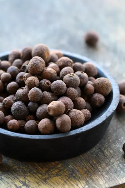 Black pepper in a wooden bowl — Stock Photo, Image