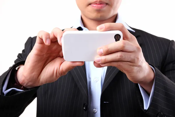 白い背景の上、携帯電話のカメラを使用するビジネスマン — ストック写真
