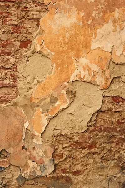 Старая кирпичная стена с рваной штукатуркой — стоковое фото
