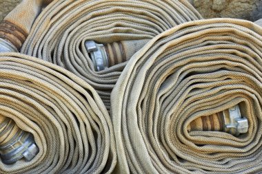 Several old rolled fire hoses clipart