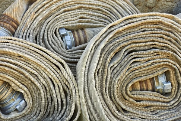 Várias mangueiras de incêndio enroladas antigas — Fotografia de Stock