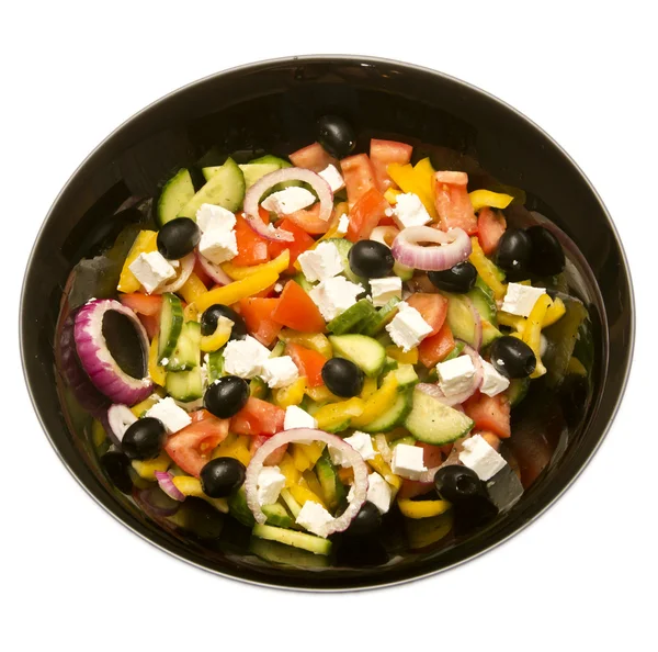 Salade grecque en assiette noire sur fond blanc — Photo