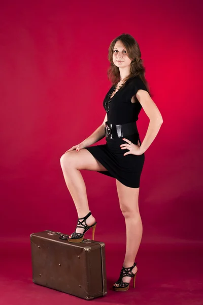 Девушка в черном платье на красном фоне — стоковое фото