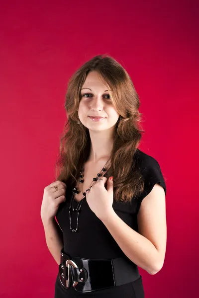 The girl in black dress on a red background — Stock Photo, Image