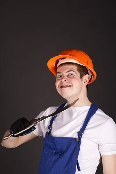 Lavoro in uniforme, un casco con un pugnale in mano su sfondo nero — Foto Stock
