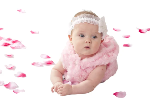Een schattige babymeisje liggend op de grond vallen in bloemblaadjes — Stockfoto