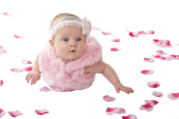 Yerde yatan bir kız şirin bebek çiçek yaprakları kaplı — Stok fotoğraf
