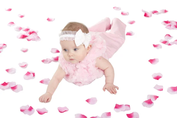 Yerde yatan bir kız şirin bebek çiçek yaprakları kaplı — Stok fotoğraf