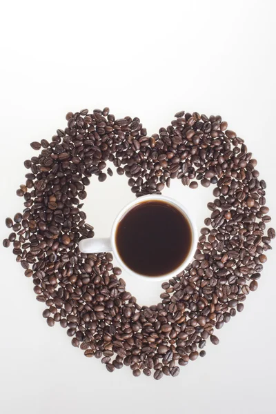 stock image Heart of the coffee beans with a cup of coffee in the heart on a white background