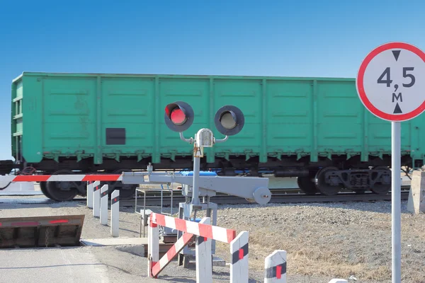 Coches de ferrocarril en el cruce con una barrera —  Fotos de Stock