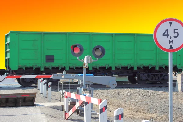 Железнодорожные вагоны на перекрестке с барьером — стоковое фото