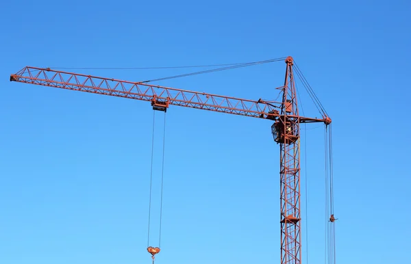 Rode kraan en blauwe hemel op de bouwplaats — Stockfoto
