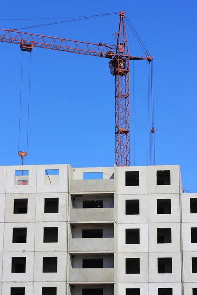 Rode kraan en blauwe hemel op de bouwplaats — Stockfoto