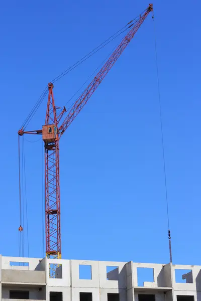Roter Kran und blauer Himmel auf Baustelle — Stockfoto