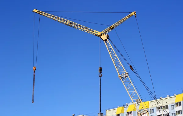 Guindaste amarelo e céu azul no local de construção — Fotografia de Stock