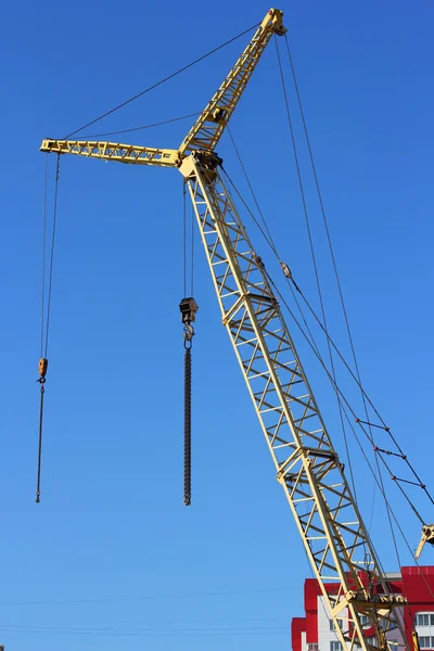 Gelber Kran und blauer Himmel auf Baustelle — Stockfoto