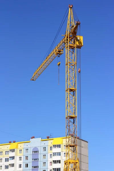 Żuraw żółty i niebieski niebo na plac budowy — Zdjęcie stockowe