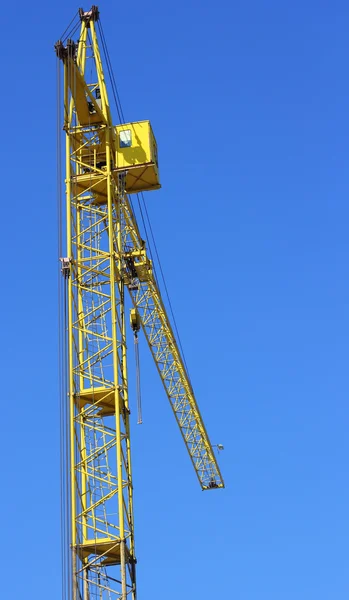 Gele kraan en blauwe hemel op de bouwplaats — Stockfoto
