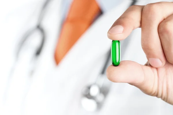 Doctor sosteniendo píldora verde — Foto de Stock