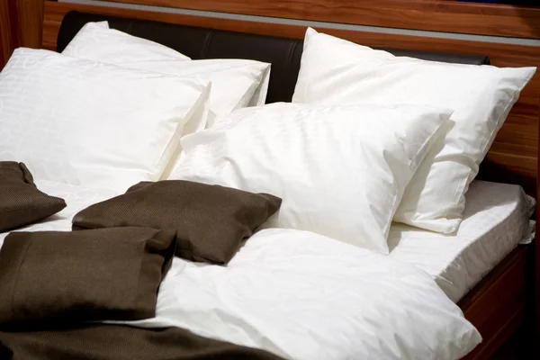 Almofadas agradáveis em uma cama contemporânea — Fotografia de Stock