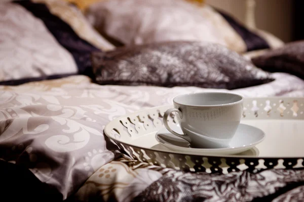 stock image One cup on a nice bed