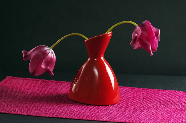 Tulipas cor-de-rosa em um vaso em um fundo preto — Fotografia de Stock