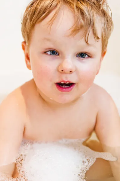 stock image The little boy bathes in bathing with foam