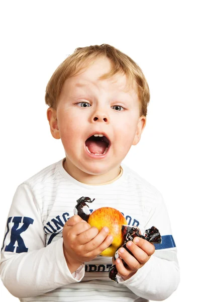 O menino com uma maçã e doces — Fotografia de Stock