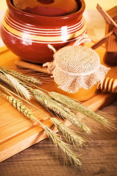 Plátky chleba a pšenice na dřevěný stůl — Stock fotografie