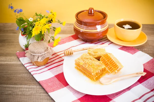 Still life with honeycombs, flowers and pot — Stock Photo, Image
