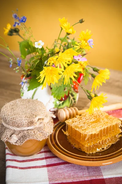 Stilleven met bloemen, honingraten en pot — Stockfoto