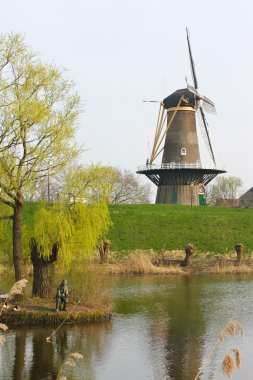 Statue of the fisherman on the background of a windmill in Gorin clipart