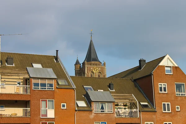 Fasaden av en moderne bygning på bakgrunn av kirken – stockfoto