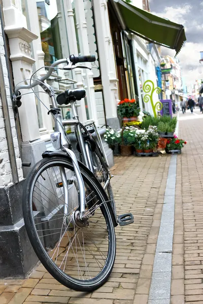 Rower jest zaparkowany w pobliżu kwiaciarni w gorinchem. Holandia — Zdjęcie stockowe
