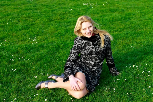 Chica feliz se sienta en una floreciente pradera de primavera por la mañana temprano — Foto de Stock