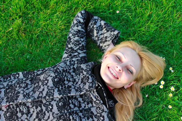 幸せな女の子は早いばねの朝に咲く草原に位置します。 — ストック写真