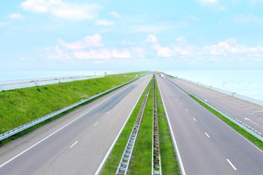 Highway on a great dam in Netherlands clipart